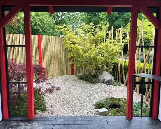Blick aus einer Gartenlaube in einen angelegten Garten