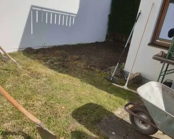 Bodenarbeiten vor der Rasenneuanlage in einem Innenhof