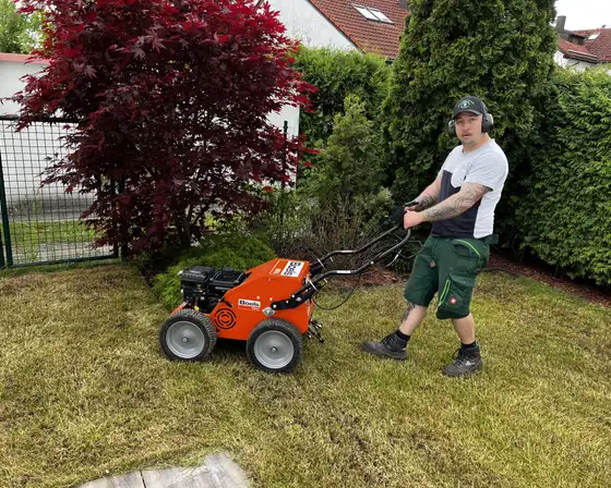 Vertikutierer im Einsatz auf einer Rasenfläche